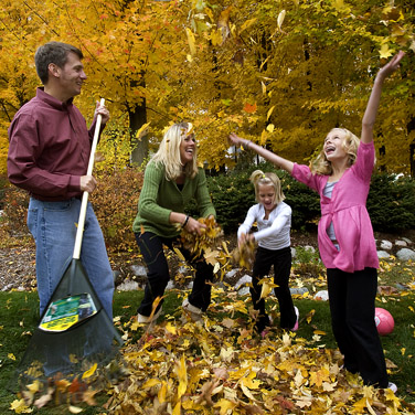 family raking leaves